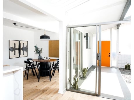 Open-concept dining area in Irvine, CA with sliding glass doors opening to a private courtyard, showcasing custom design in Orange County.
