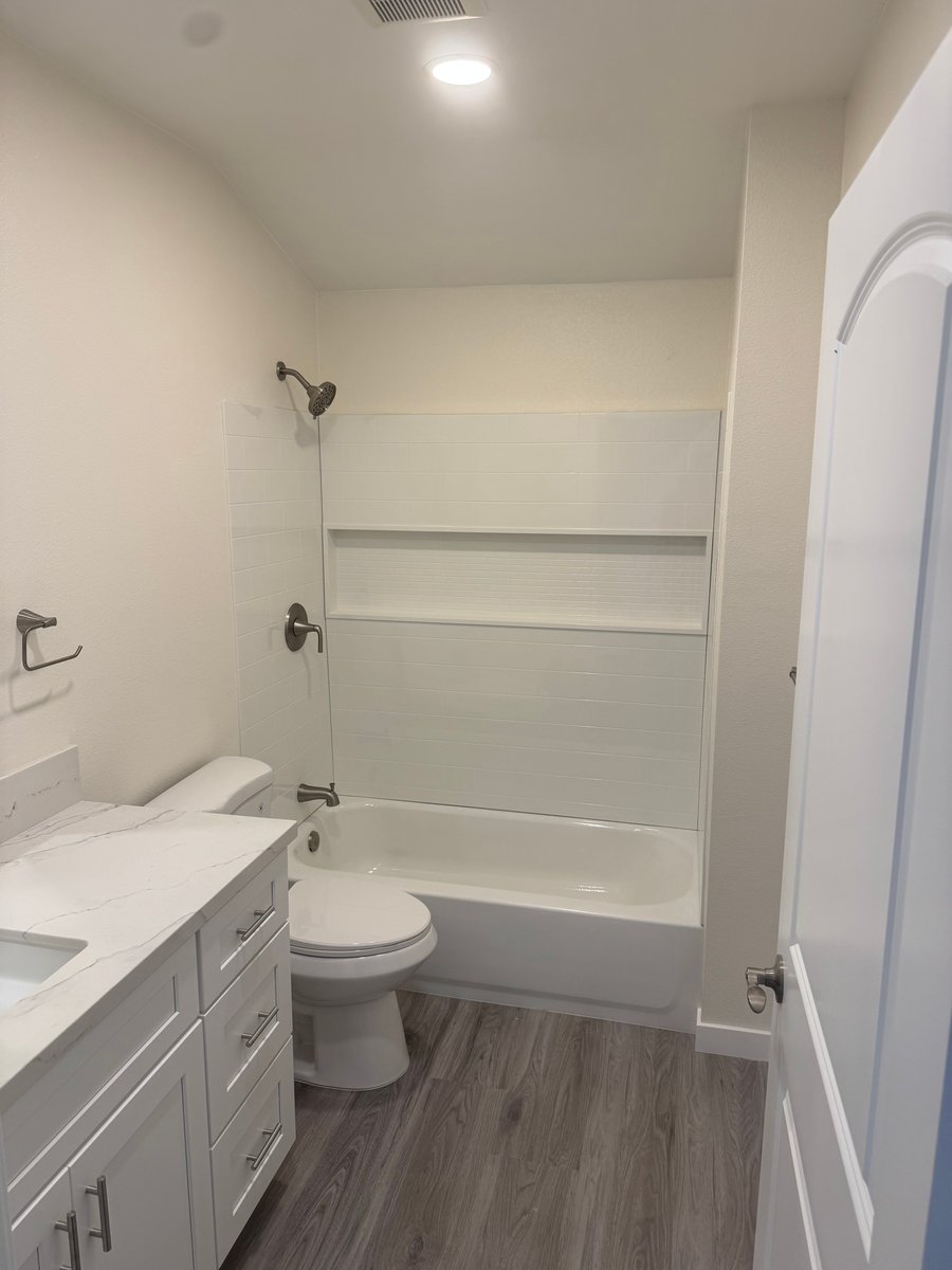 ADU bathroom with tub shower combo, built-in wall niche, and brushed nickel fixtures
