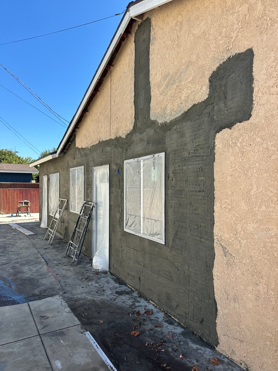 ADU exterior during construction with new stucco finish and windows installed