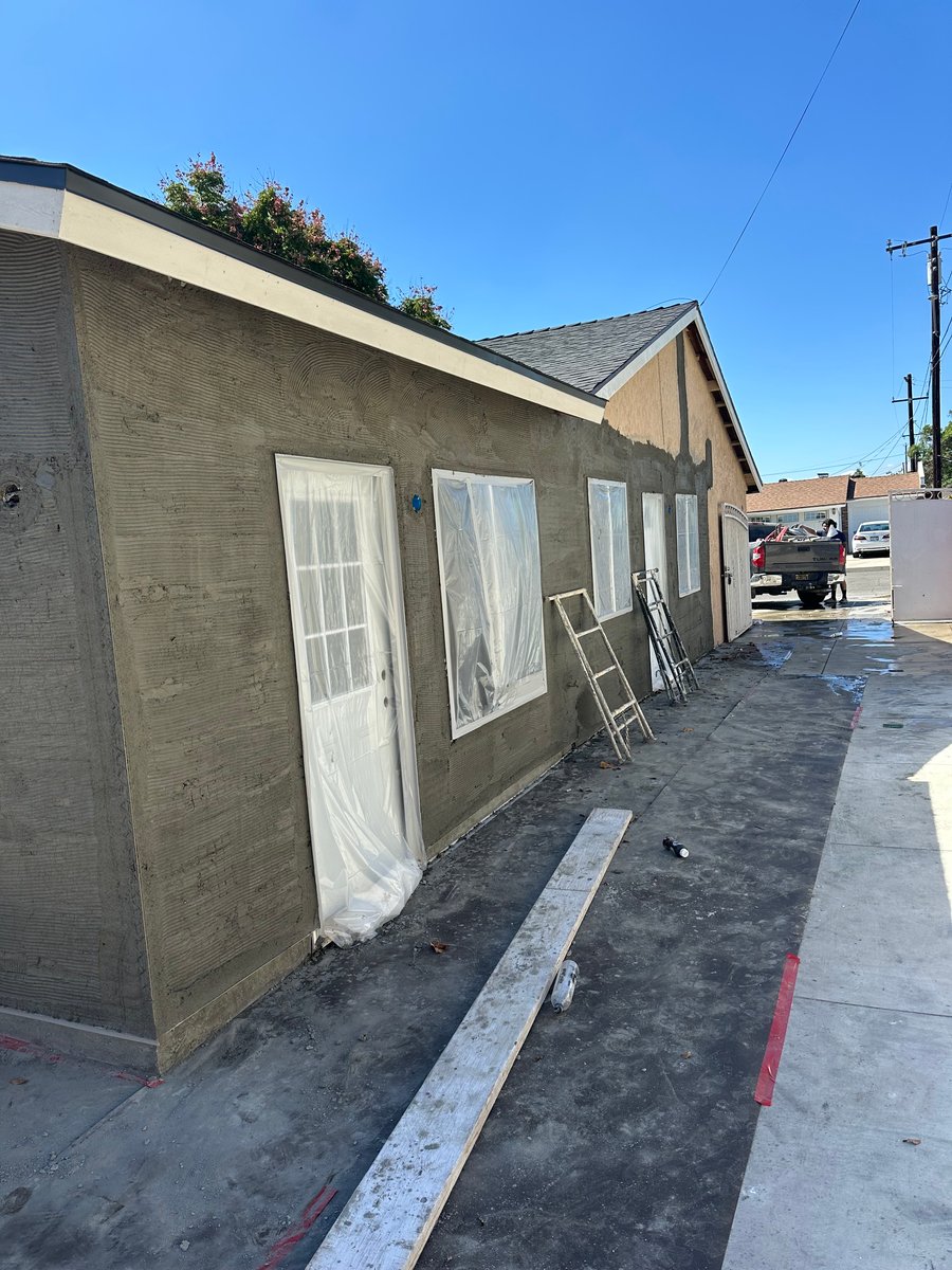 ADU exterior during construction with new stucco finish and windows installed
