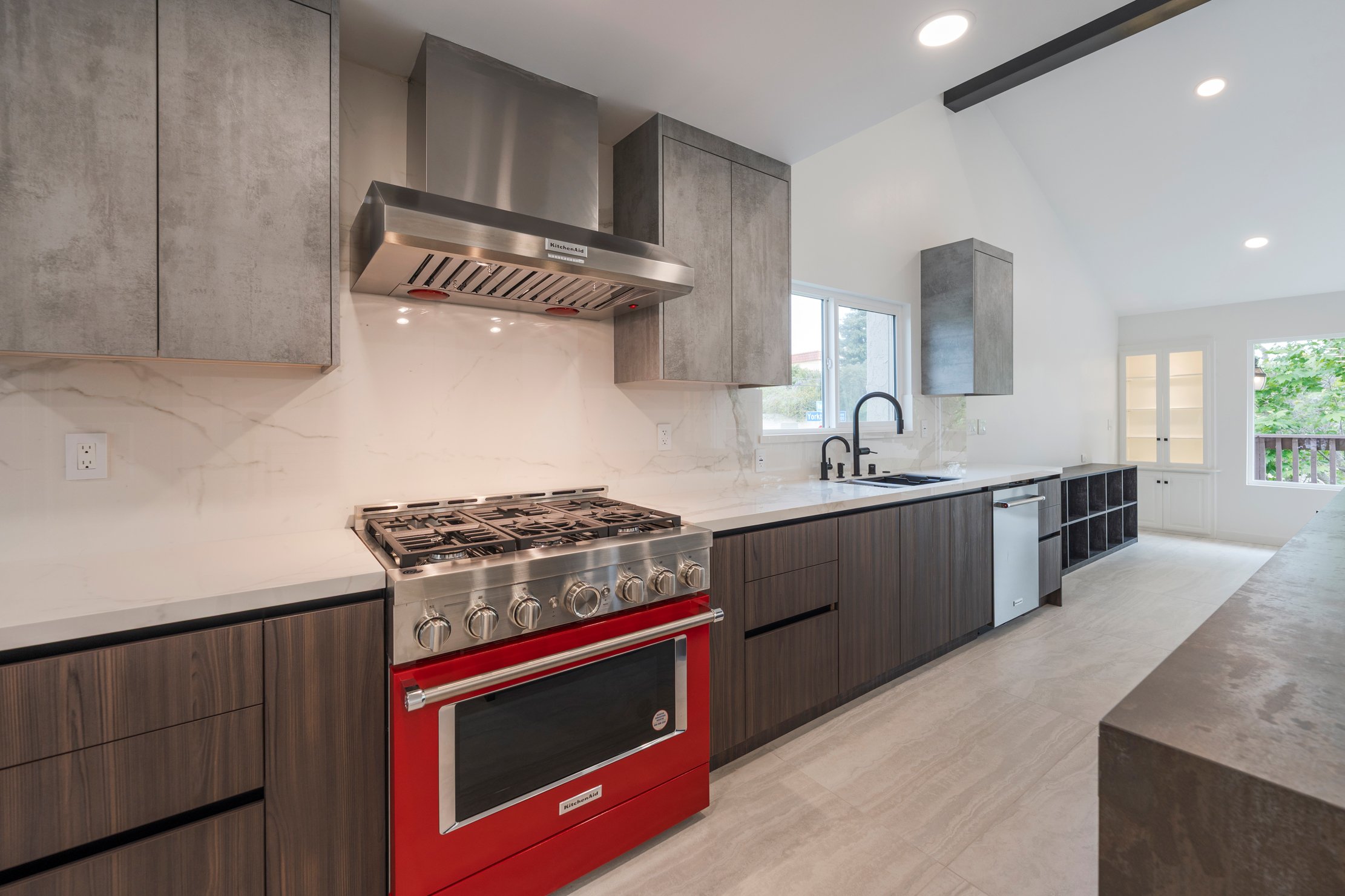 Long modern ADU kitchen layout with red range, quartz backsplash, and custom cabinetry in Corona, CA