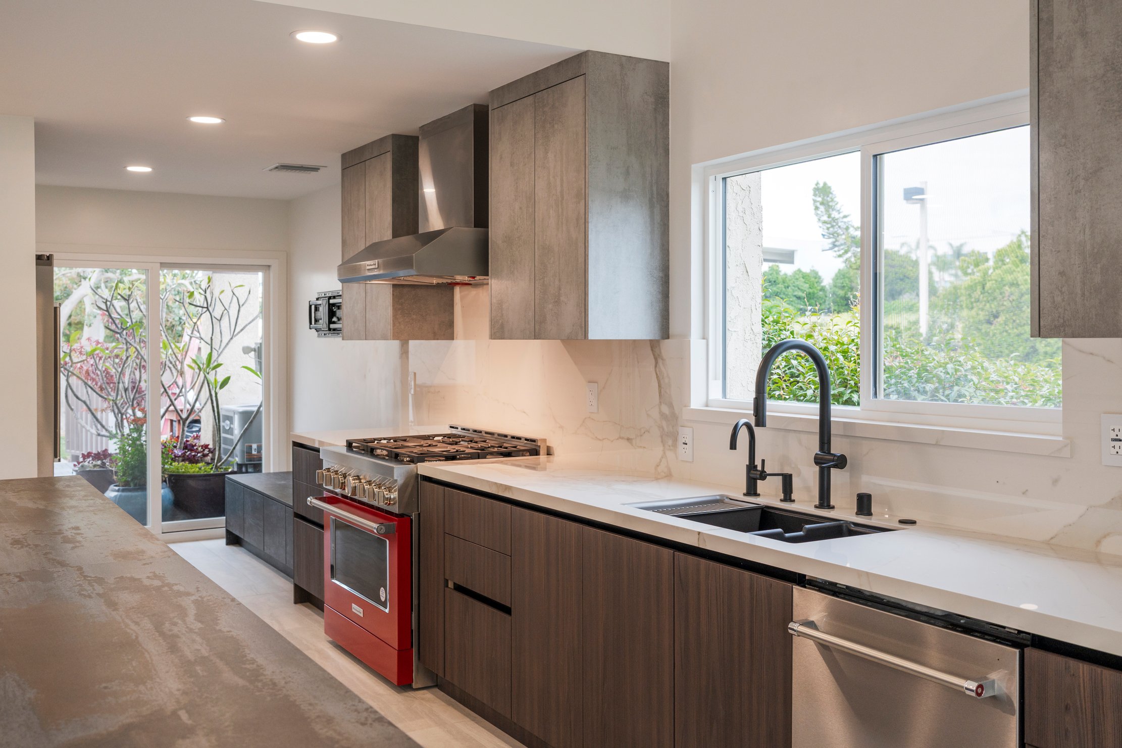 Modern ADU kitchen with white quartz counters, matte black faucet, and custom wood cabinets 